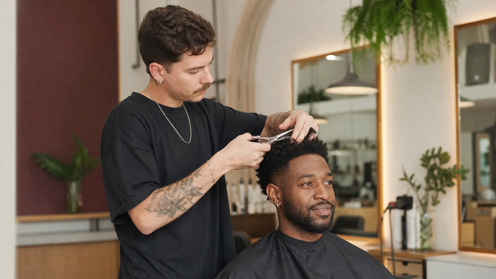 Profissional branco cortando o cabelo de um cliente negro em um espaço de beleza inclusivo